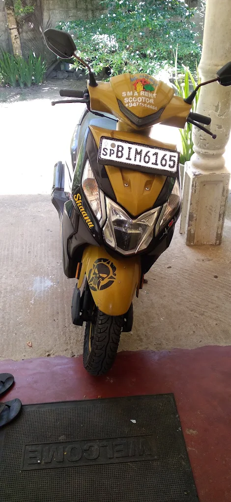Yellow Honda Dio scooter with SMA branding